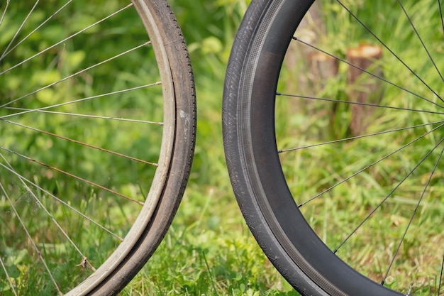 Metallrad eines alten Vintage-Fahrrads und hochkarätiges schwarzes Carbonrad eines modernen Rennrads