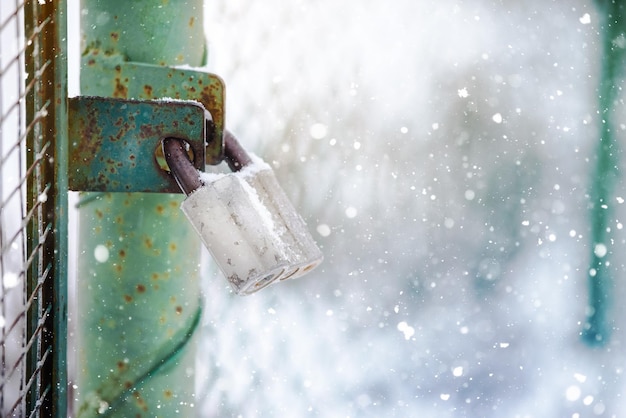 Metallschloss am Tor im Schnee Das Konzept des Endes der Ferienzeit