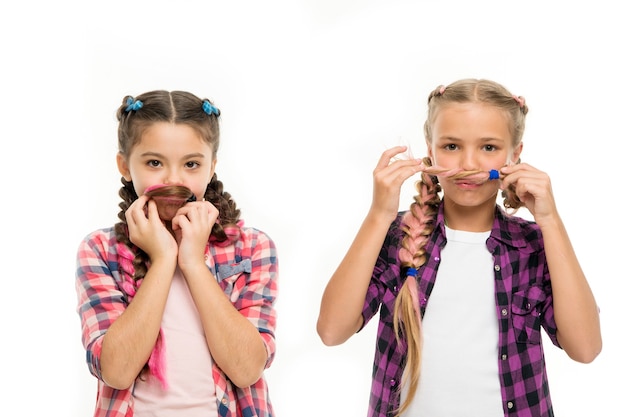 Metas de hermandad. Hermanas juntas fondo blanco aislado. Relación fraternal. La hermandad es amor incondicional. Niñas hermanas juguetonas que se divierten con el pelo largo. Concepto de cuidado del cabello y peinado.