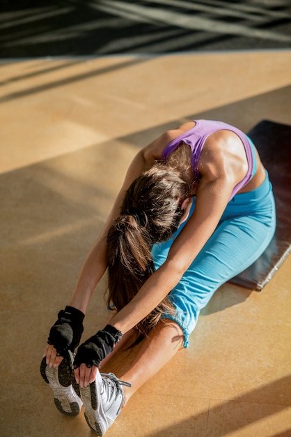 Foto metas de pareja. fíjese en una pareja fuerte haciendo ejercicio en un gimnasio. hombre ayudando a niña con abdominales.