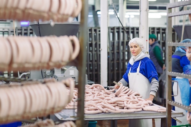 Foto metzger, die würste an der fleischfabrik verarbeiten.