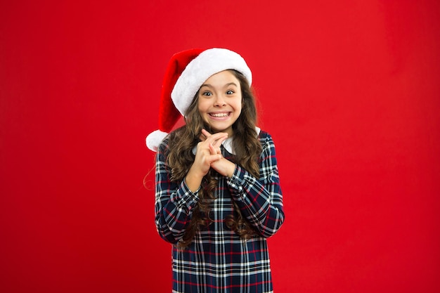 Meu maior desejo. Boas férias de inverno. Menina pequena. Presente para o Natal. Infância. Compras de Natal. Menina com chapéu vermelho de Papai Noel. Festa de Ano Novo. Criança do Papai Noel. celebração familiar.