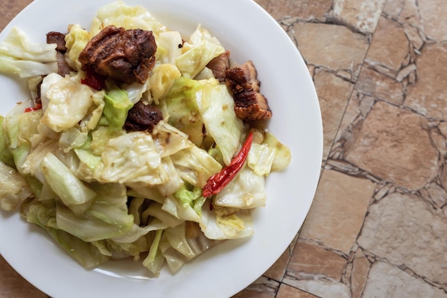 Mexa couve frita com carne de porco frita no prato para café da manhã ou almoço ou menu de jantar na mesa de comida