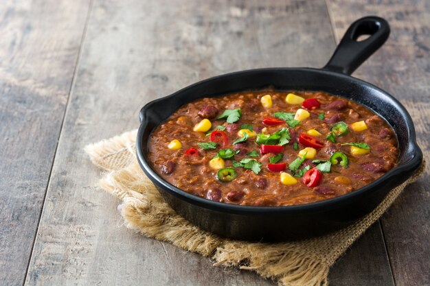 Mexicano tradicional tex mex chili com carne em uma frigideira na mesa de madeira