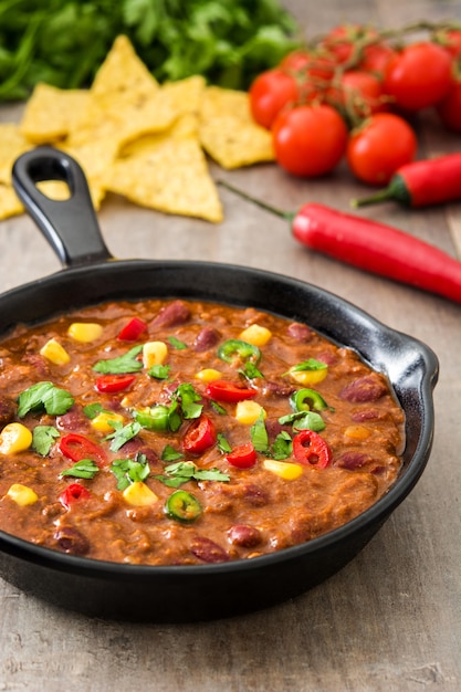 Mexicano tradicional tex mex chili com carne em uma frigideira na mesa de madeira