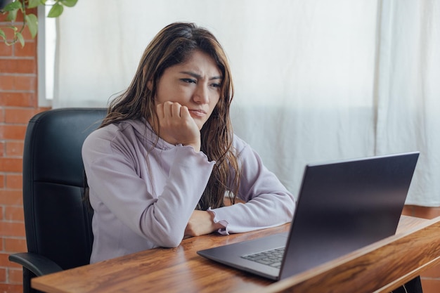 Mexikanerin im Heimbüro wütend und frustriert vor dem Computer