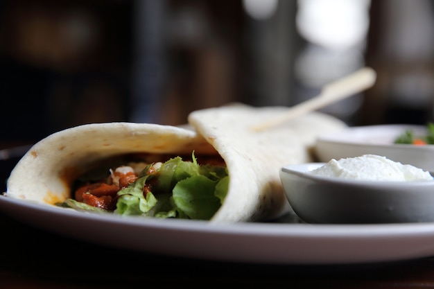 Mexikanische Burritos auf einem Teller mit Tomatensalat