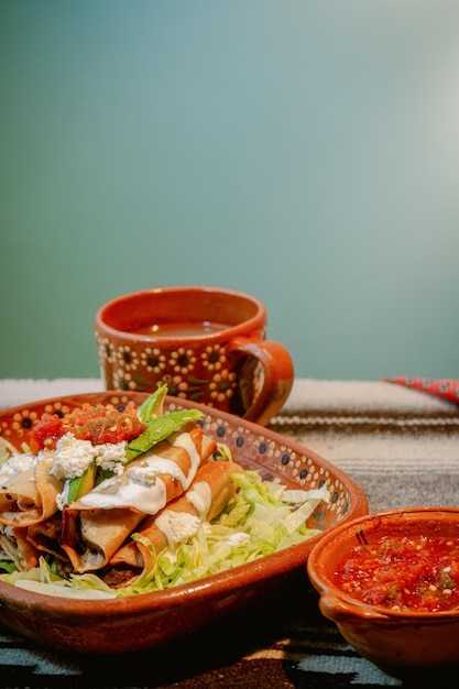 Mexikanische Flautas mit Salat-Avocado-Sahnesauce und frischem Wasser