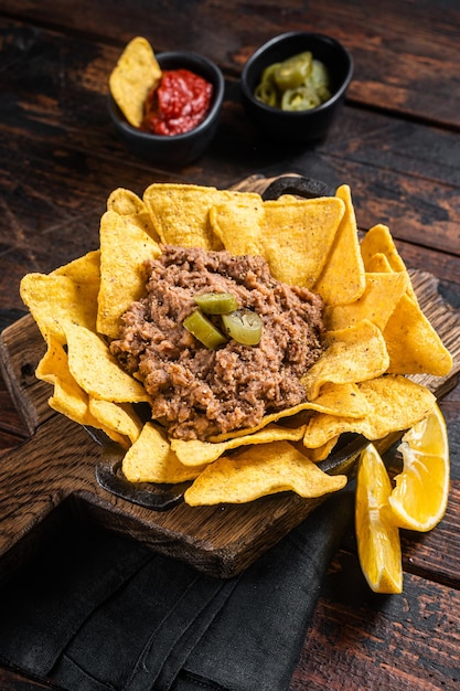 Mexikanische gebackene Nachos mit Chili con Carne in einer Pfanne Holzhintergrund Draufsicht