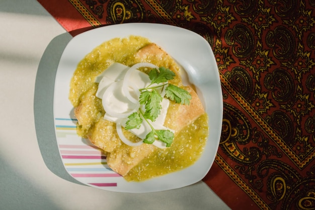 Mexikanische grüne Enchiladas mit Hühnerkäse, Koriander und Zwiebeln