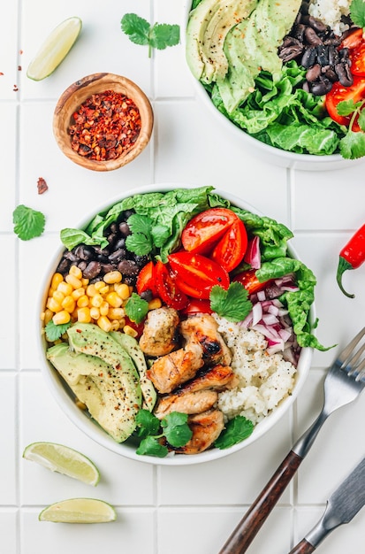 Mexikanische Hühnchen-Burrito-Schüssel mit Reisbohnen-Tomaten-Avocadocorn und Salat