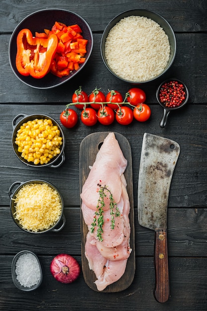 Mexikanische Lebensmittelzutaten Huhn Enchilada, Reisauflauf, auf schwarzem Holztisch, Draufsicht flach legen