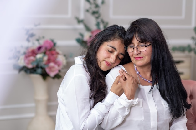 Mexikanische Mutter und Tochter umarmen sich am Muttertag