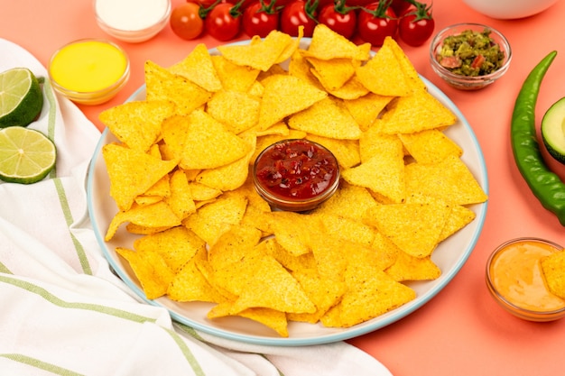 Mexikanische Nachos-Mais-Chips auf einem Teller mit Soße und Gemüse Mexikanische Küche