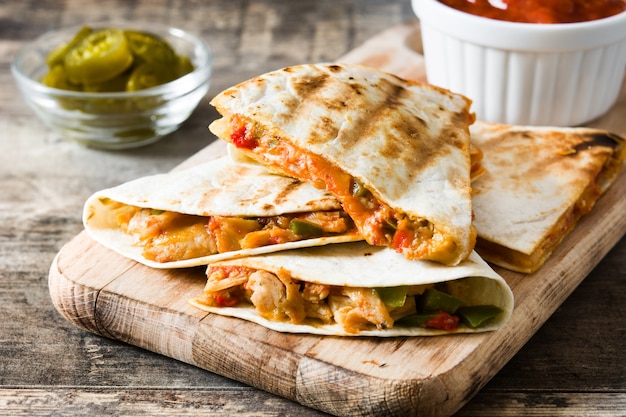 Mexikanische Quesadilla mit Huhn, Käse und Paprika auf Holztisch