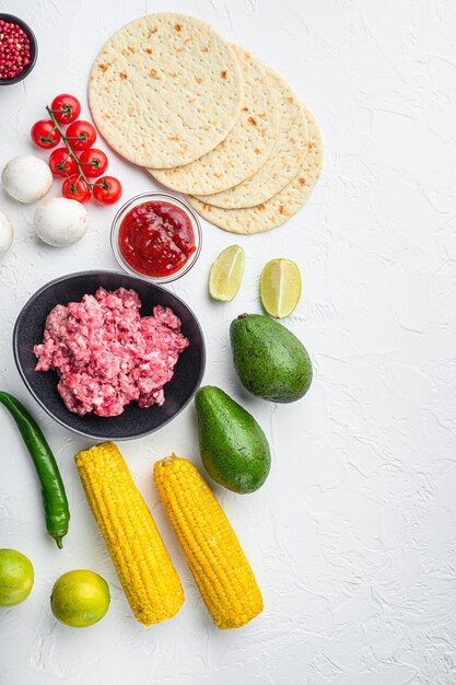 Mexikanische Tacos mit Gemüse und Fleisch. Zutat zum Kochen, Draufsicht auf weißem Hintergrund mit Platz für Text.