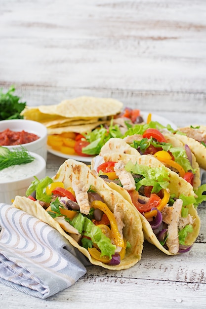 Mexikanische Tacos mit Hühnchen, Paprika, schwarzen Bohnen und frischem Gemüse