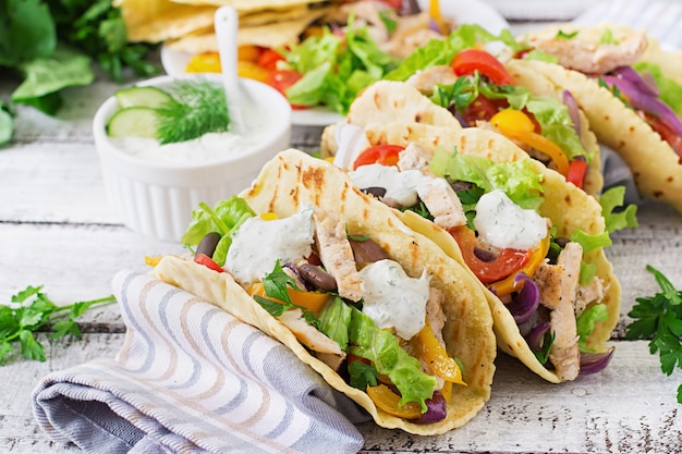 Mexikanische Tacos mit Hühnchen, Paprika, schwarzen Bohnen und frischem Gemüse