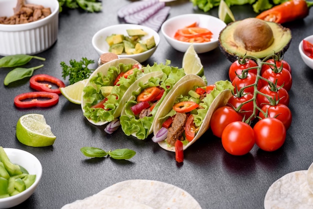 Mexikanische Tacos mit Rindfleisch, Tomaten, Avocado, Zwiebeln und Salsasauce