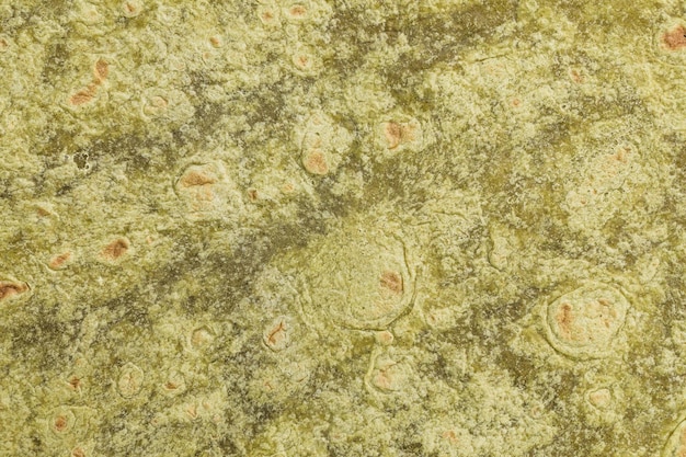 Mexikanische Weizentortilla mit Spinatgeschmack wickelt Texturhintergrund ein