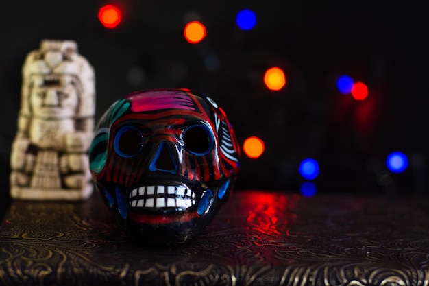 Mexikanischer Dia de Muertos-Schädel auf schwarzem Hintergrund mit Lichtern