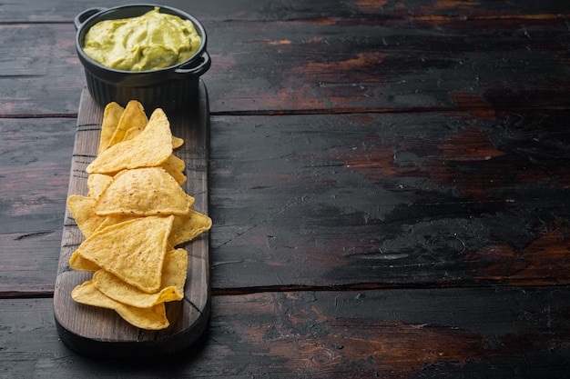 Mexikanischer knuspriger Snack, Nachos-Chips und Käse-Guacamole-Avocado-Saucen auf altem Holztisch