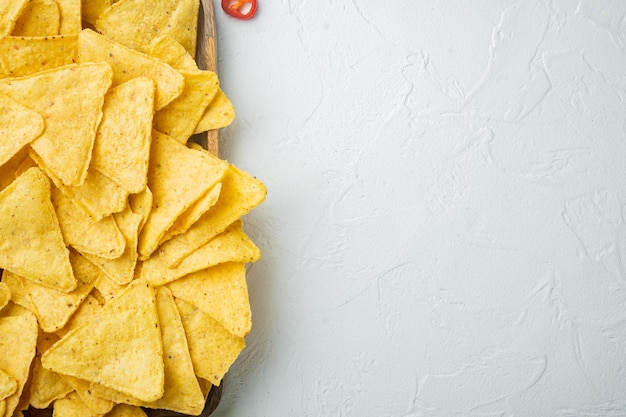 Mexikanischer knuspriger Snack, Nachos-Chips und Käse-Guacamole-Avocado-Saucen, auf weißem Hintergrund, Draufsicht oder flach mit Kopienraum für Text