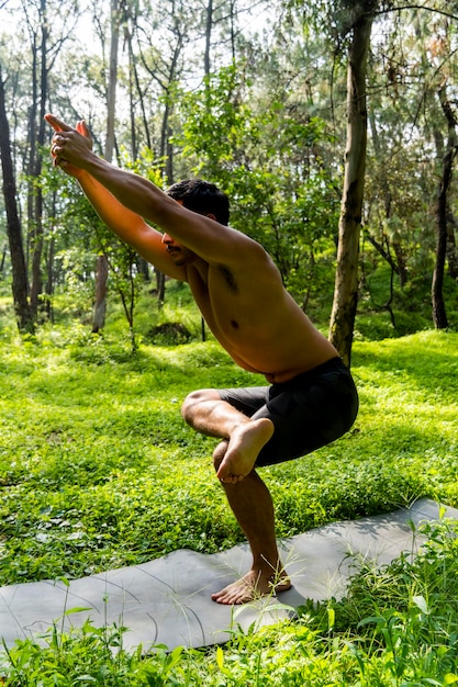 Mexikanischer Mann, der Yoga macht und sich im Wald Mexiko ausdehnt