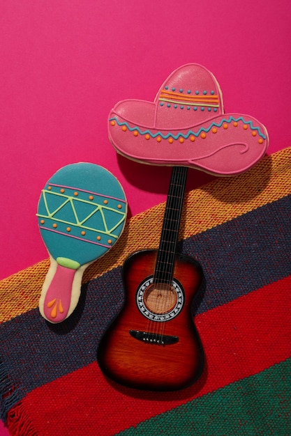 Foto mexikanischer sombrero mit einer dekorativen gitarre auf einem rosa hintergrund
