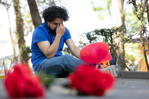 Mexikanischer trauriger Mann, der auf dem Boden sitzt, schlechtes Datum Valentine39s Day Copy Space
