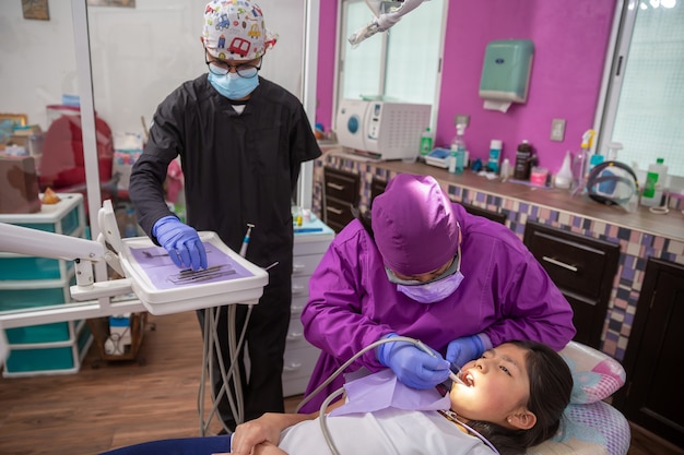 Mexikanischer Zahnarzt, medizinische Untersuchung der Mundhöhle einer Patientin mit zahnärztlichen Instrumenten