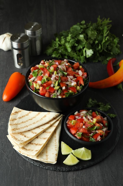 Mexikanisches Essenskonzept mit Pico de Gallo auf dunklem Holztisch