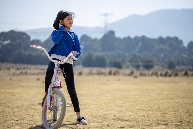 Mexikanisches Mädchen auf Fahrrad im Freien