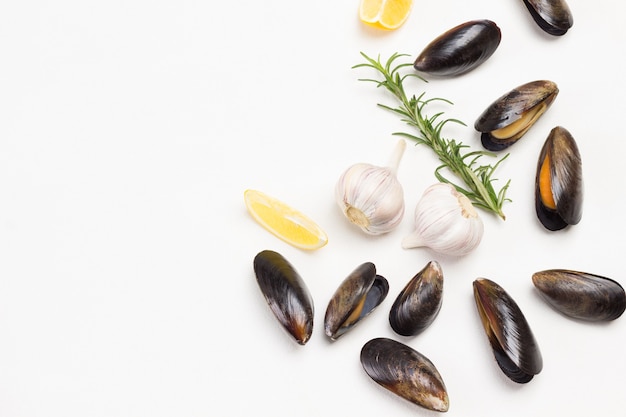Mexilhões com limão, alho e alecrim são espalhados na mesa. Frutos do mar de marisco.