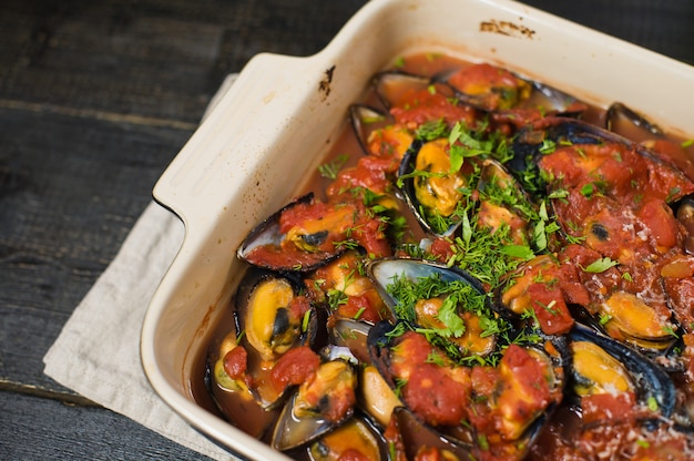 Mexilhões cozidos no molho de tomate com coentro e parmesão.