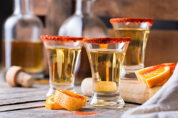 Mezcal mexicano ou mescal com pimenta malagueta e uma rodela de laranja. bebida alcoólica semelhante à tequila