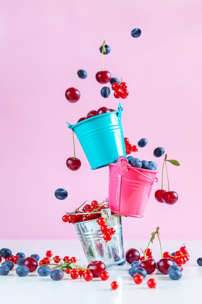 Mezcla de bayas frescas en pequeños cubos Fondo rosa