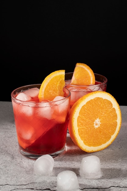 Foto mezcla de cócteles en vasos con cubitos de hielo y rodajas de naranja