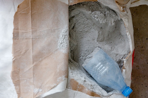 Mezcla de construcción gris en polvo seco en una bolsa de cartón