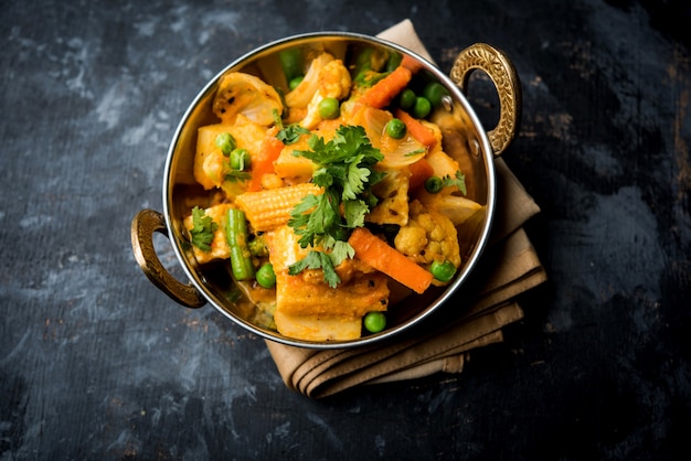 Mezcla de curry de verduras: la receta del plato principal indio contiene zanahorias, coliflor, guisantes y frijoles, maíz tierno, pimiento y paneer o requesón con masala tradicional y curry