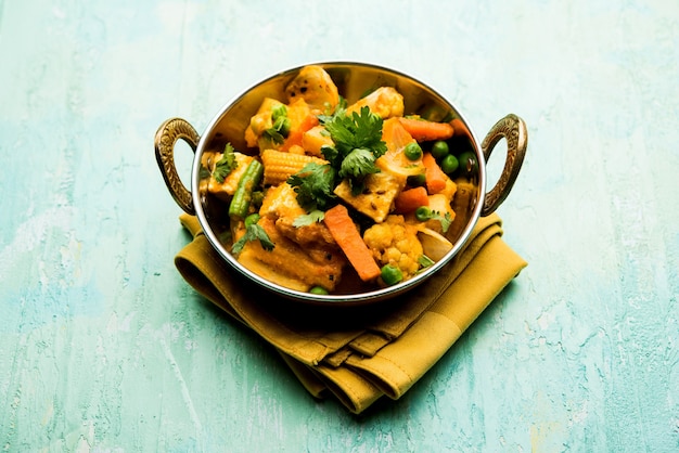 Mezcla de curry de verduras: la receta del plato principal indio contiene zanahorias, coliflor, guisantes y frijoles, maíz tierno, pimiento y paneer o requesón con masala tradicional y curry