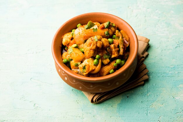 Mezcla de curry de verduras: la receta del plato principal indio contiene zanahorias, coliflor, guisantes y frijoles, maíz tierno, pimiento y paneer o requesón con masala tradicional y curry