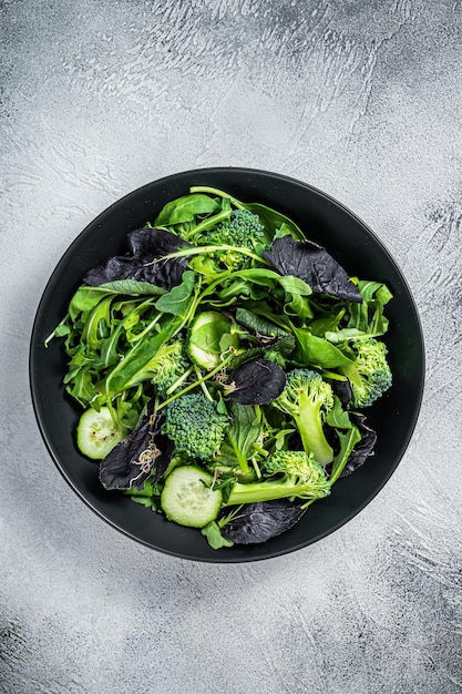 Mezcla de ensalada fresca de espinacas, hojas de rúcula, acelgas y canónigos con verduras Fondo blanco Vista superior