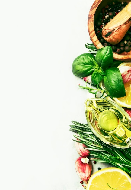 Mezcla de especias hierbas picantes frescas romero albahaca verde ajo rojo pimiento surtido aceite de oliva en la mesa de la cocina gris fondo de cocina vista superior