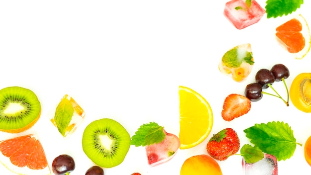 Mezcla de frutas frescas y jugosas, bayas y hielo sobre un fondo blanco.