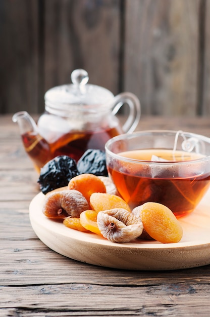 Mezcla de frutas secas con una taza de té negro.
