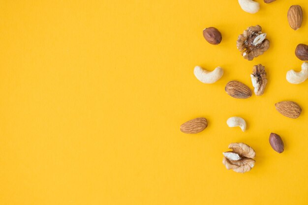 Mezcla de frutos secos para una dieta saludable anacardo maní avellanas nueces almendras sobre fondo amarillo