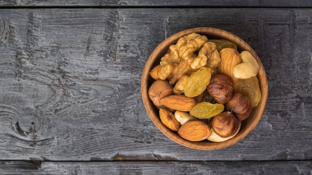 Una mezcla de frutos secos y nueces diversas sobre una mesa de madera. Comida vegetariana saludable natural. Endecha plana.