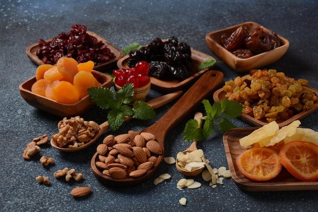 Mezcla de frutos secos y secados al sol en bandejas de madera Vista desde arriba Símbolos de la festividad judía de Tu BiShvat