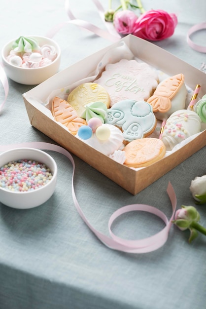 Mezcla de galletas de Pascua en la caja de papel en la imagen de enfoque selectivo de mesa azul claro